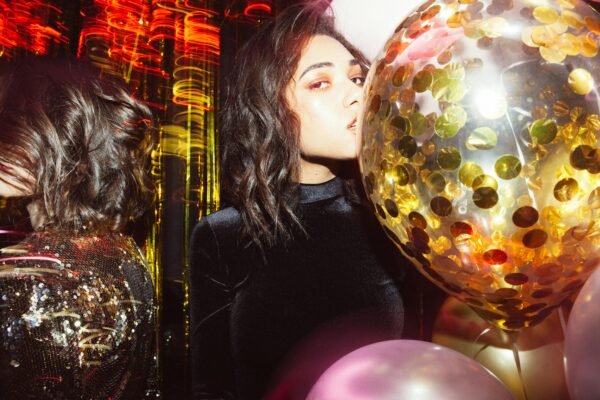 Woman at party with glitter balloon, symbolizing luxury and going out during ADE.