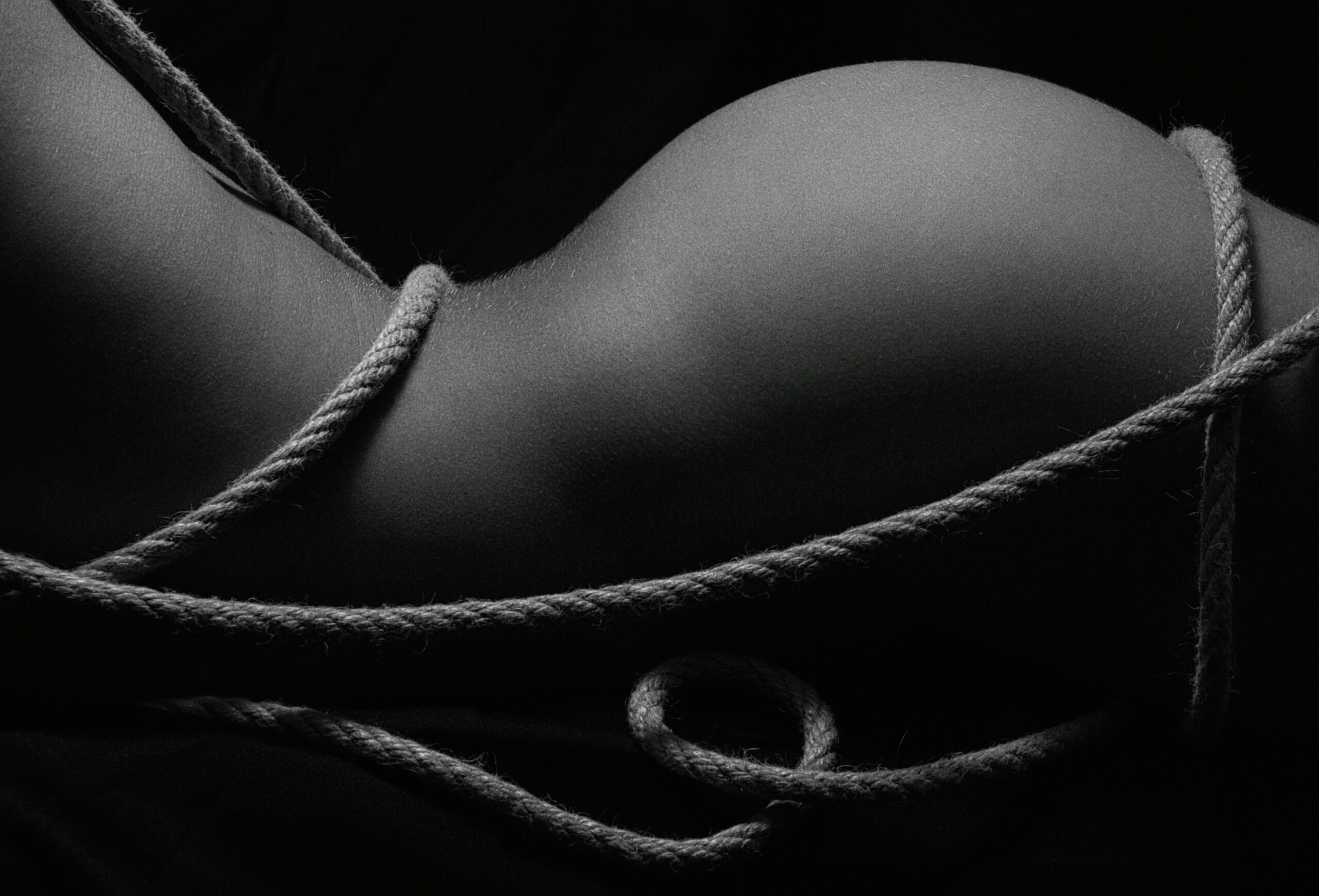 zwart-wit foto van billen en een bloot lichaam. Ingewikkeld met touw
